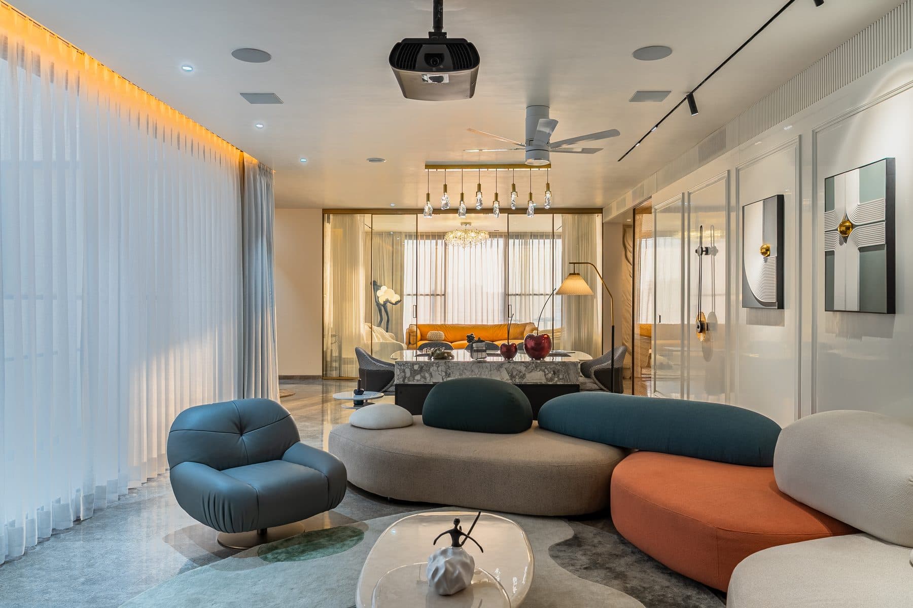 Lounge corner at the end of the dining: curved sofa in taupe, teal and burnt orange, teal swivel chair