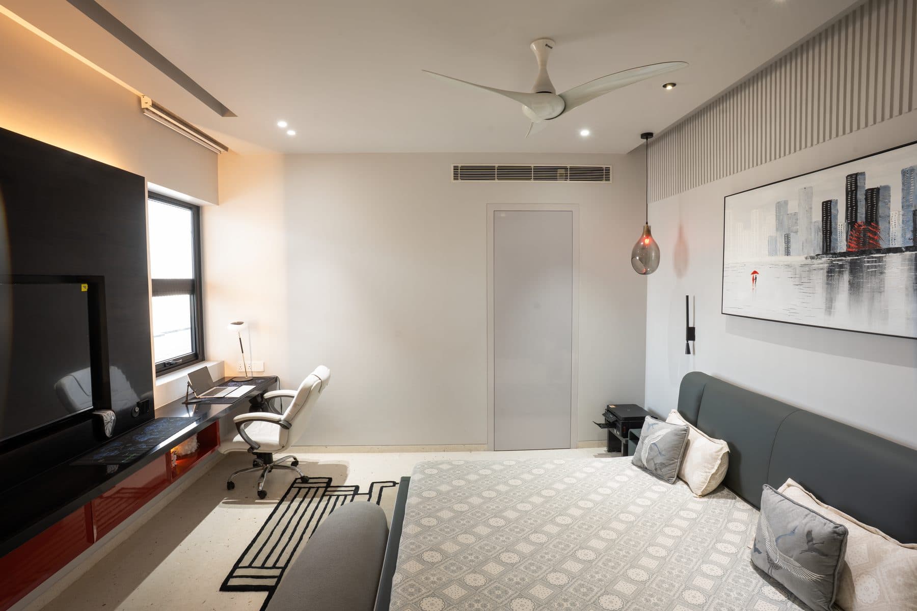 Bedroom with a black TV wall, a red-fronted study desk, a smoked-glass pendant and a cityscape painting